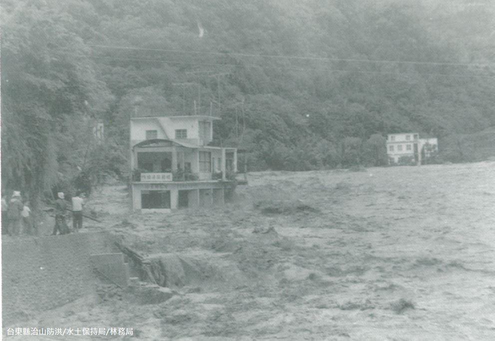 1973年娜拉颱風造成知本溪堤防潰，沖毀房舍，照片位置位於溫泉橋西側，相近位置98年莫拉克時亦曾破堤。2009年聯合報有一篇報導：「莫拉克颱風造成知本溪山洪暴發，沖垮金帥飯店及臨溪一排店舖，也沖刷出卅七年娜拉颱風侵襲時被深埋在土石下的「寶島特產店」等十二間商家遺址」(http://blog.udn.com/giveman/3231890)。
報導中所提到的「寶島特產店」，就是照片裡的建築物。