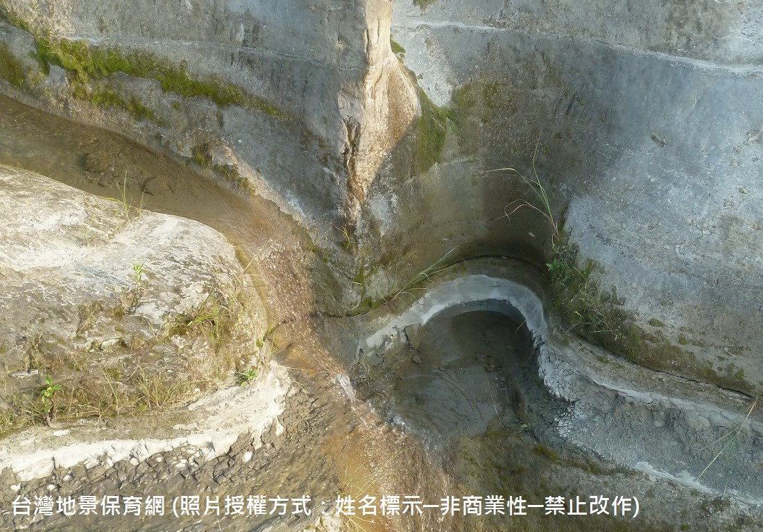 本圖呈現峽谷的壺穴景觀。壺穴是河水帶動石塊滾磨河床所造成，但從圖中沒有水流，而岩石表面仍有水流流經與青苔生長的痕跡判斷，本河道應屬於大雨來臨、流量增加時才有水流的間歇性河道。